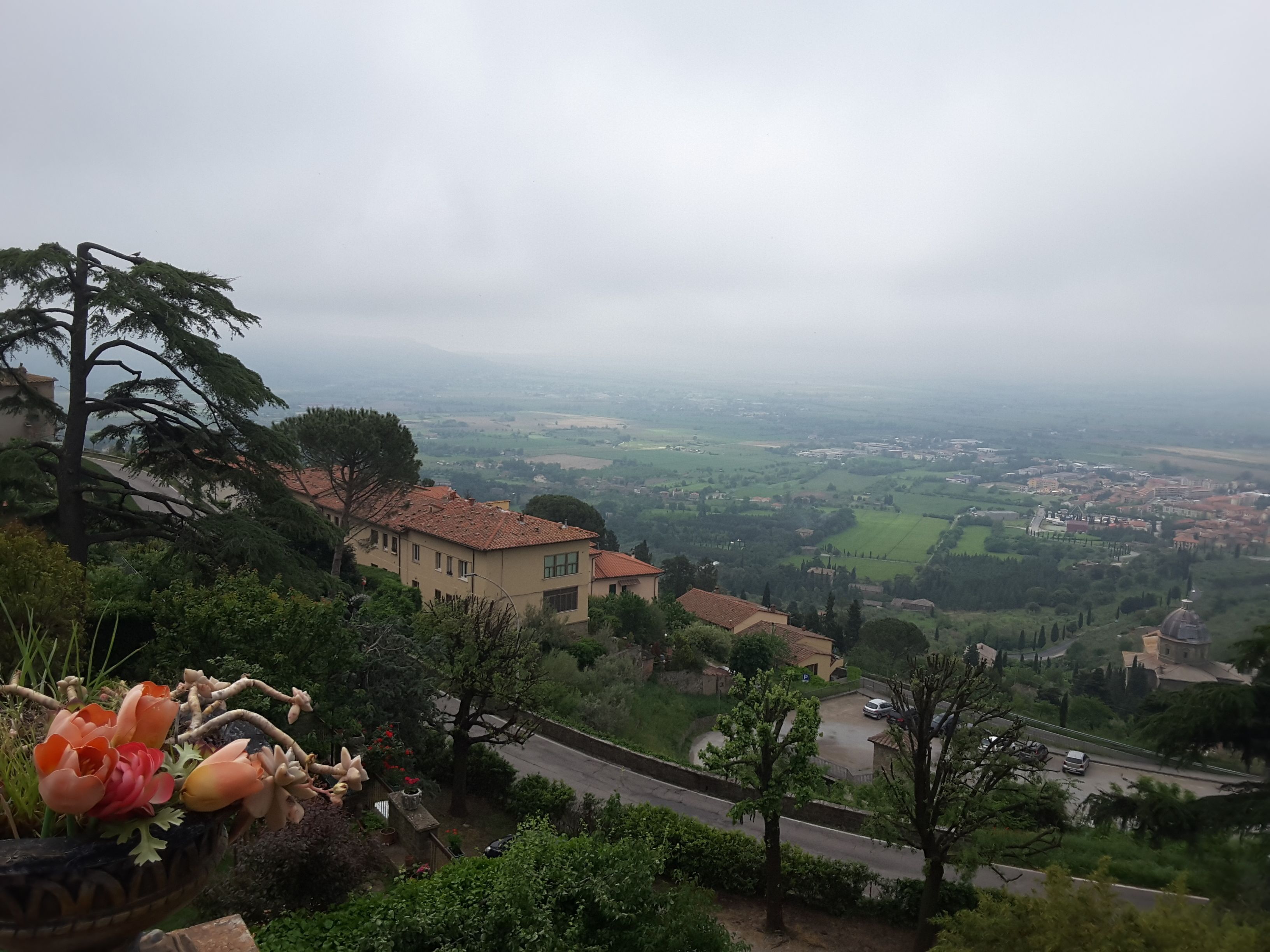 A hillside view with a building, a road, and a valley.