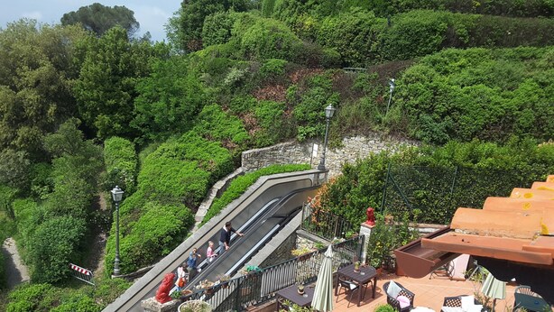 A terraced garden with a stone staircase, outdoor seating, and a red statue. - Casa Kita (Cortona)