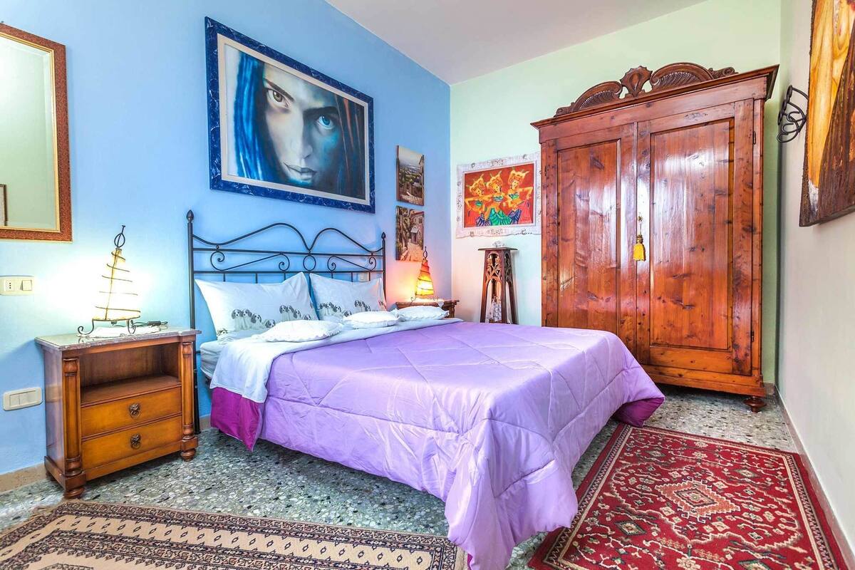 Ein Schlafzimmer mit einem Bett, einem Holzschrank und einem Nachttisch mit Lampe.