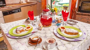 A breakfast table with pastries, a pitcher of red beverage, and a coffee cup. - Casa Kita (Cortona)