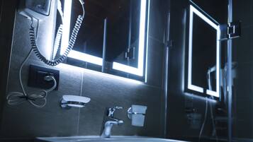 Un baño con lavabo, espejo y secador de pelo.