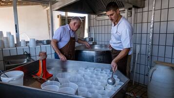 A commercial kitchen with stainless steel surfaces, a large pot, and multiple plastic containers.