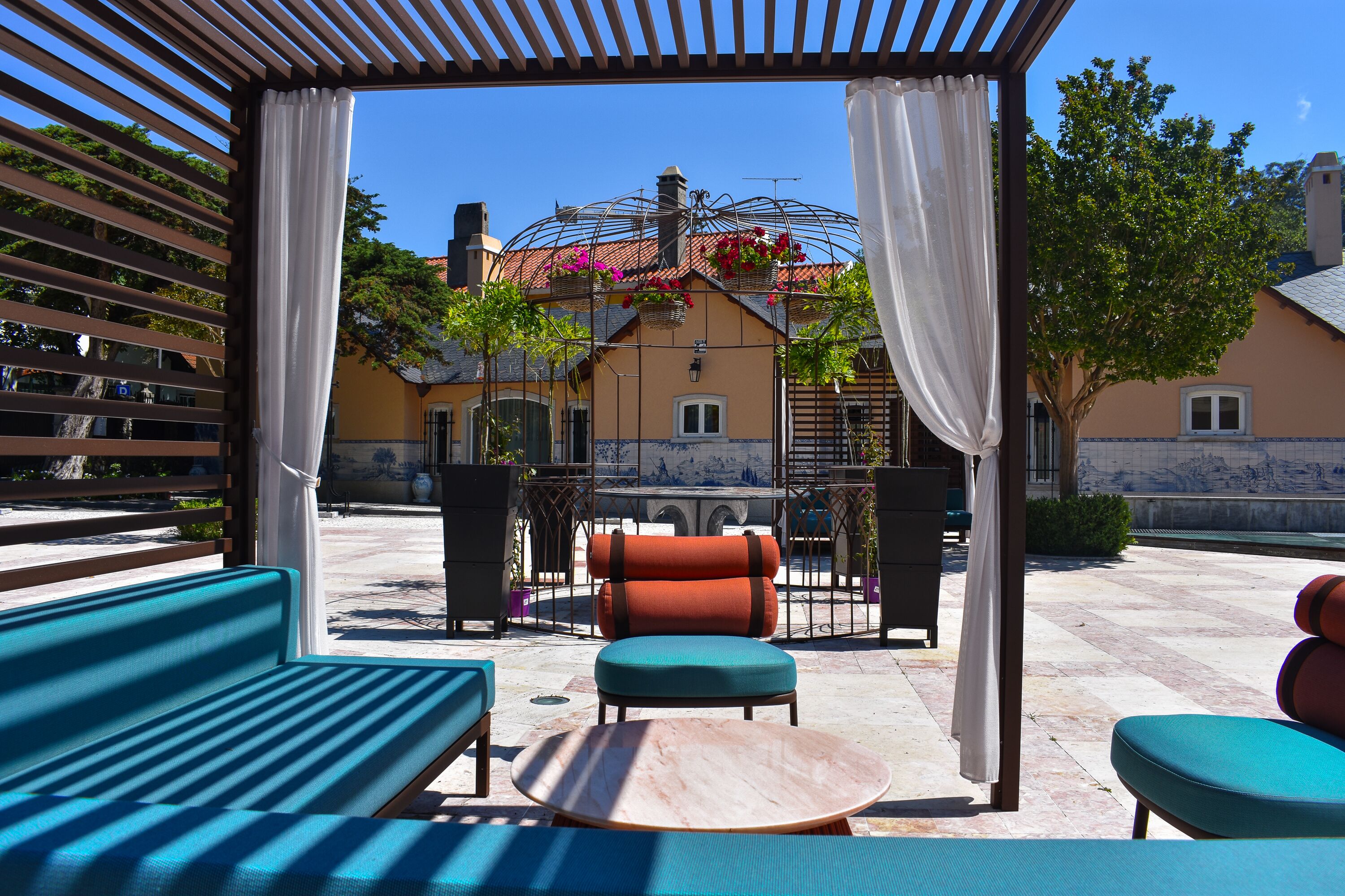 Un área de estar al aire libre con una pérgola, una mesa y sillas.