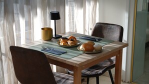 A dining table with a placemat, plates of pastries, a lamp, and chairs. - Hotel Lepelbed Melle (Melle)