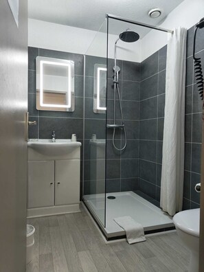 Badkamer | Een douche, een haardroger, handdoeken, zeep