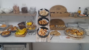 Un bufé de desayuno con diversos alimentos y utensilios.
