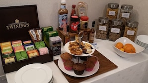 Un buffet de petit-déjeuner comprenant du thé Twinings, du café HP, des condiments et des fruits frais.