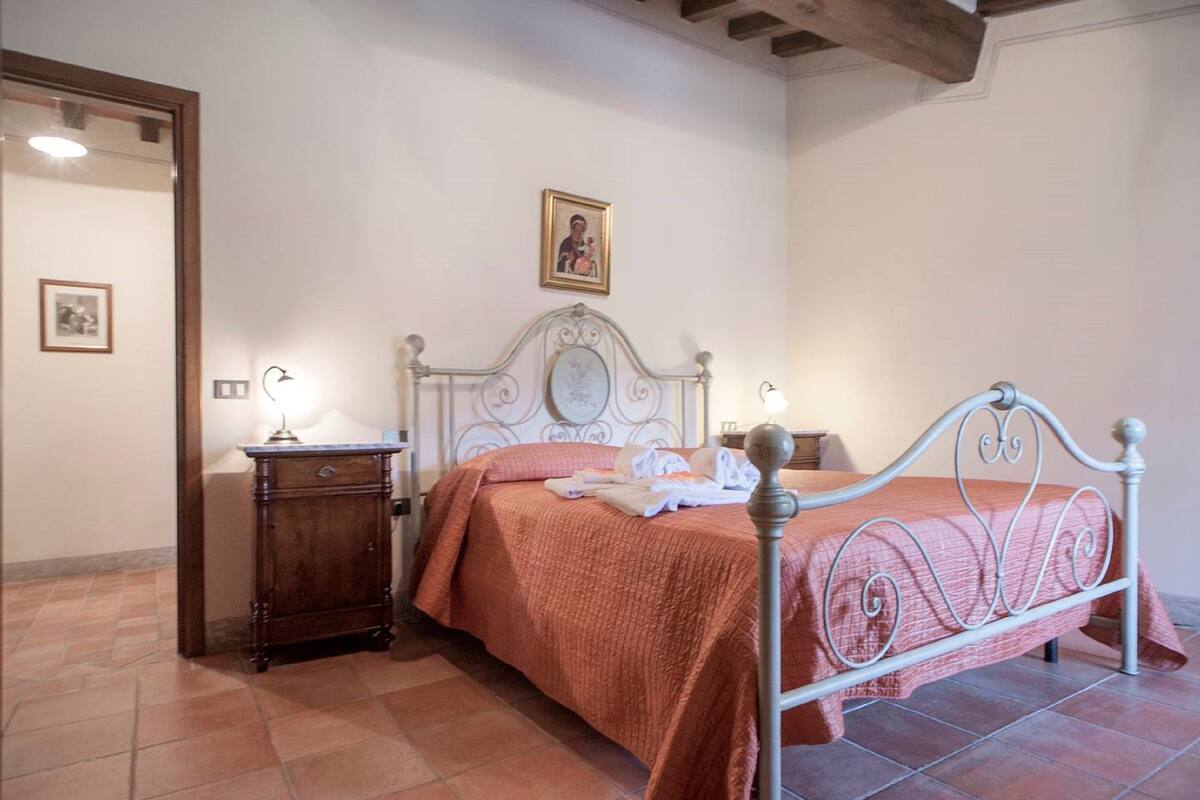 Une chambre à coucher avec un lit, une table de chevet et un tableau accroché au mur.