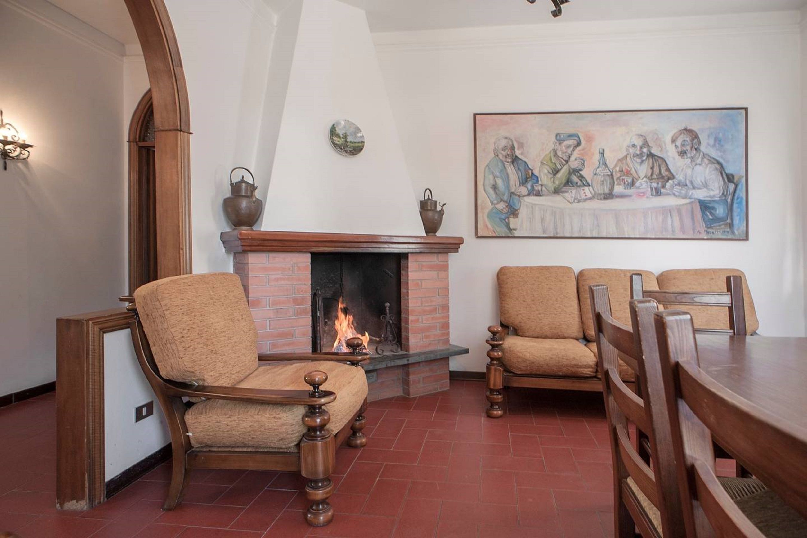 A cozy room with a fireplace, wooden chairs, and a dining table.