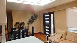 Un comedor con una mesa, sillas y una planta en maceta.