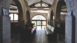 A corridor with stone walls, arched ceilings, and benches. - A' Cunziria (Vizzini)