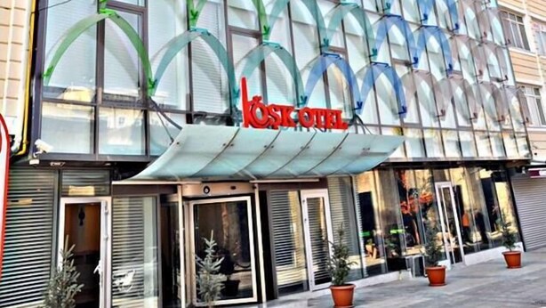 A hotel with a modern glass facade and a prominent red logo. - Kayseri Kosk Otel (Kayseri)