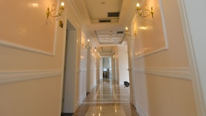 A long, well-lit hallway with ornate wall moldings and chandeliers. - Hotel Luani Arte (Shkodër)