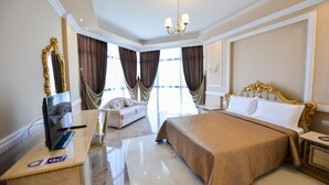 A hotel room with a large bed, a desk with a computer, a chair, and a large mirror. - Hotel Luani Arte (Shkodër)