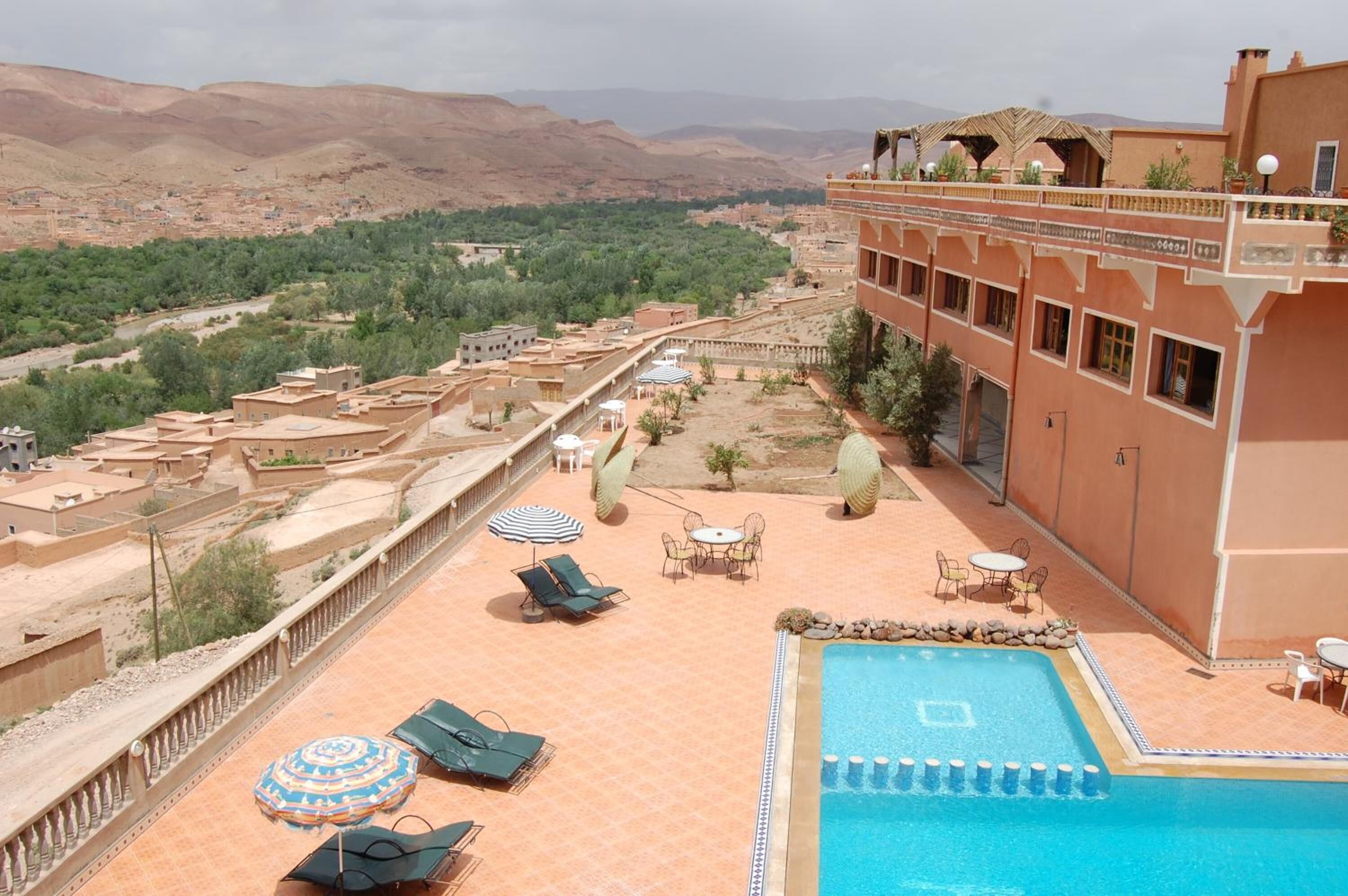 Un hôtel doté d’une piscine, d’un espace extérieur aménagé et offrant une vue sur un paysage montagneux.