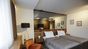 Een hotelkamer met twee bedden, een stoel, een bureau, een televisie en een spiegel.