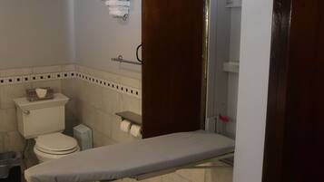 A bathroom with a toilet, sink, and shower area.