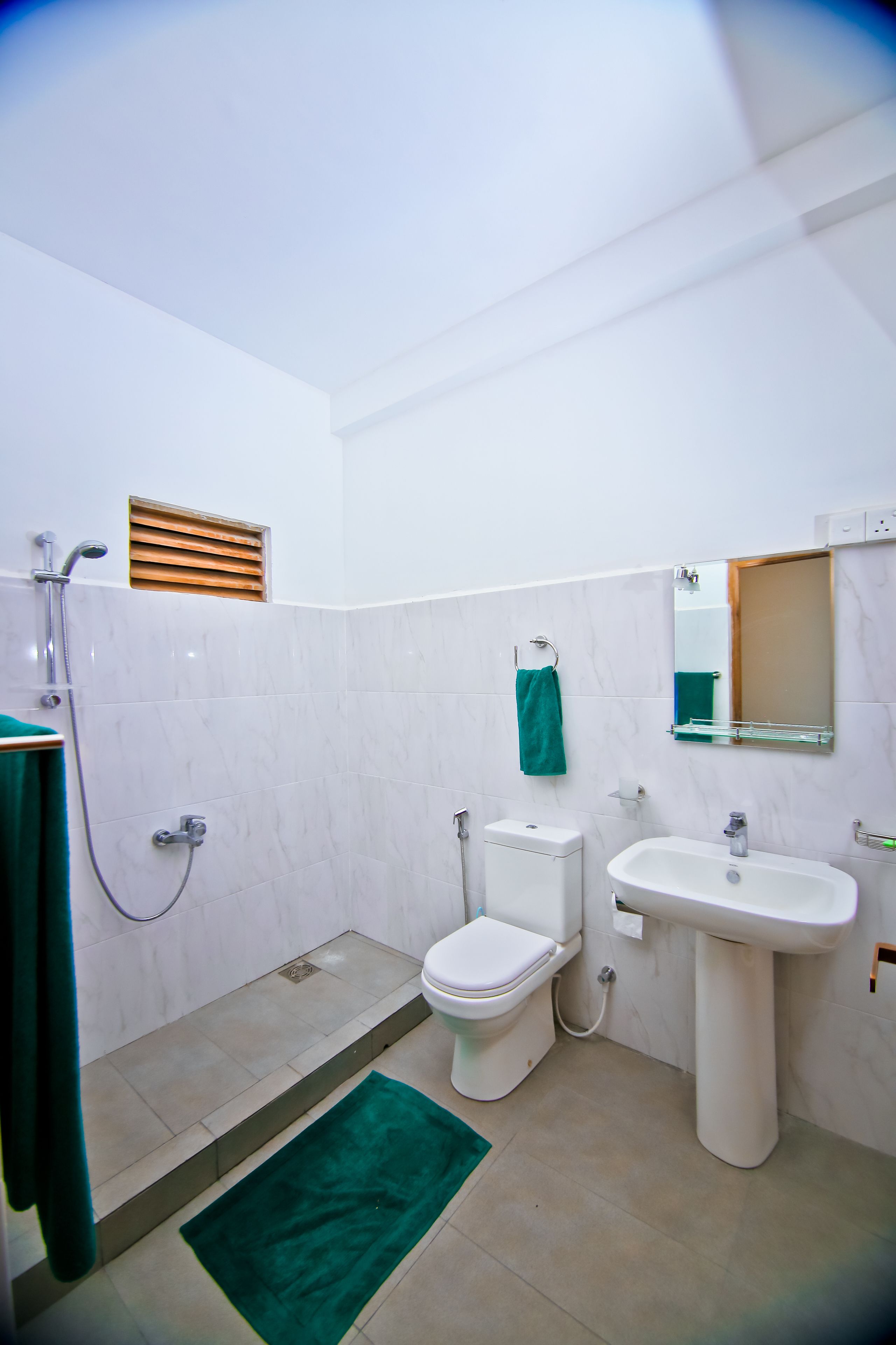 A bathroom with a toilet, sink, and shower.