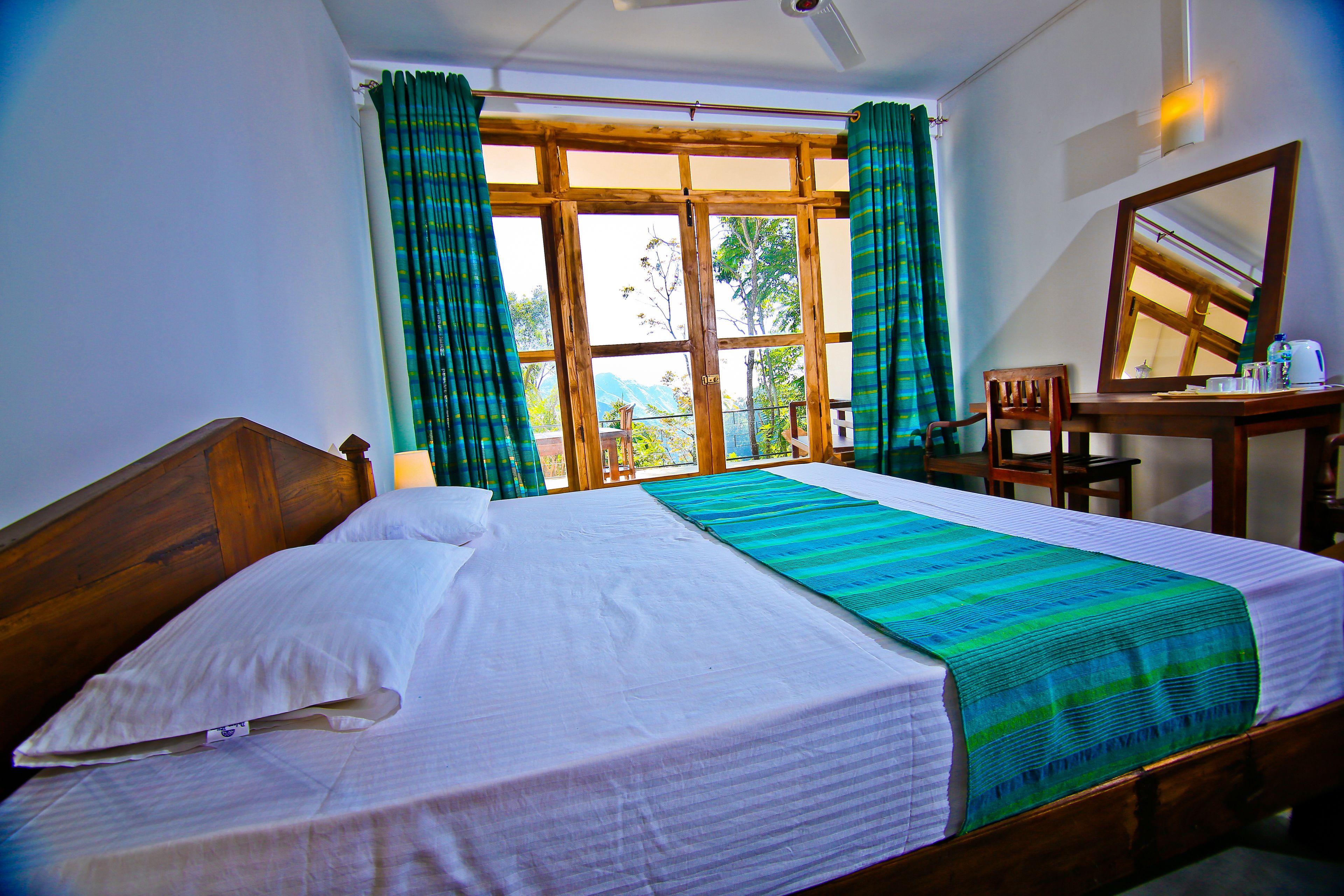 A neatly made bed with a striped blanket, a wooden headboard, and a window with curtains.
