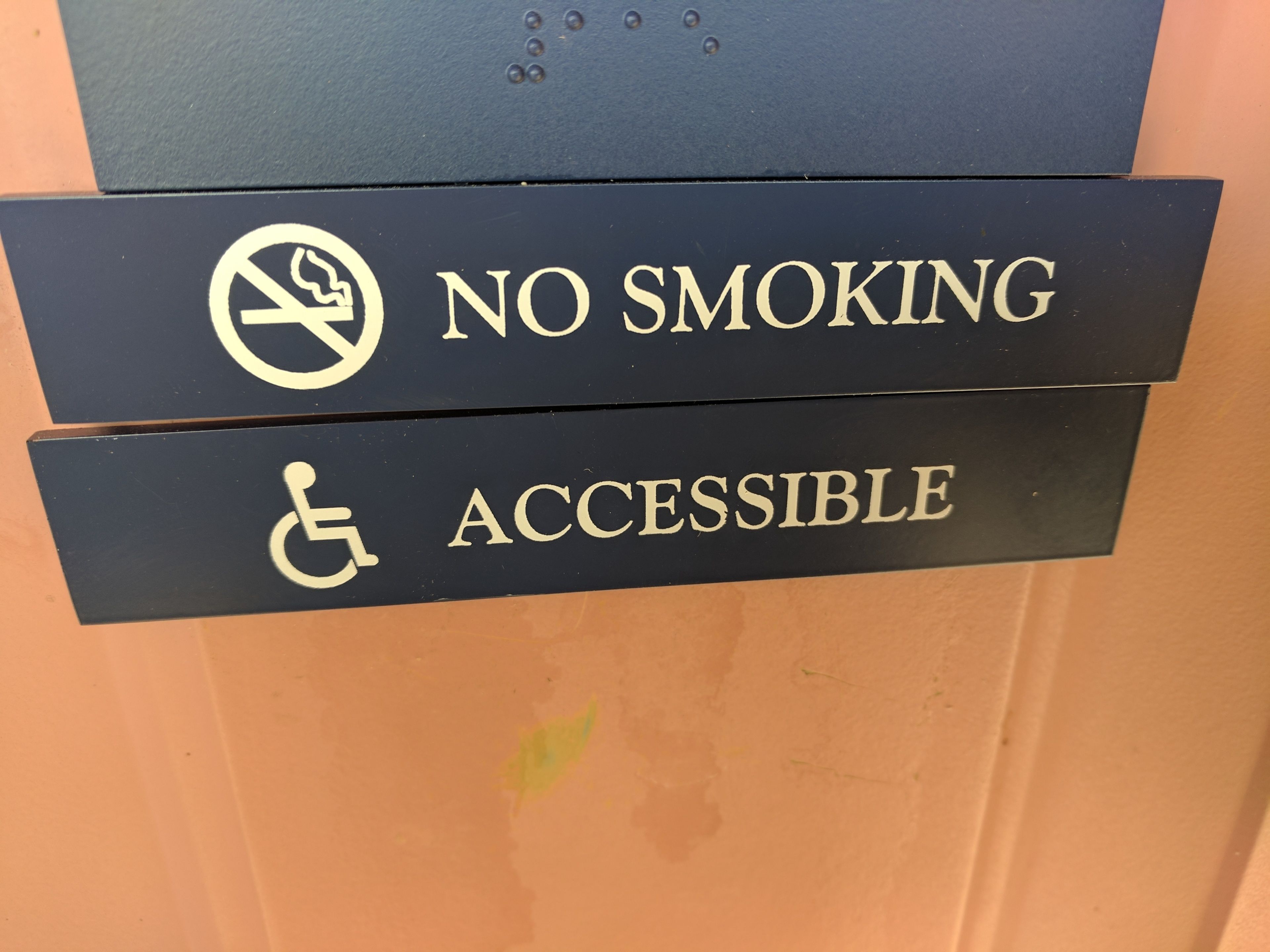 A sign indicating 'NO SMOKING' and 'ACCESSIBLE' with a wheelchair symbol.