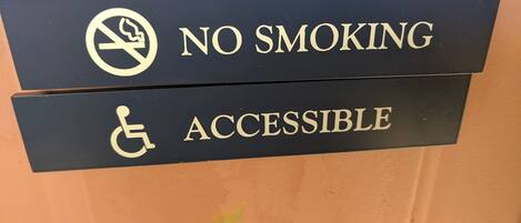 A sign indicating 'NO SMOKING' and 'ACCESSIBLE' with a wheelchair symbol.