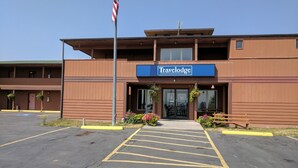 A Travelodge hotel with a parking lot, a flag, and a signboard. - Travelodge by Wyndham Three Forks (Three Forks)