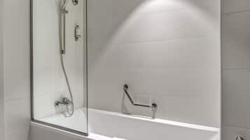 A modern bathroom with a glass-enclosed shower, a white bathtub, and a grab bar for safety.