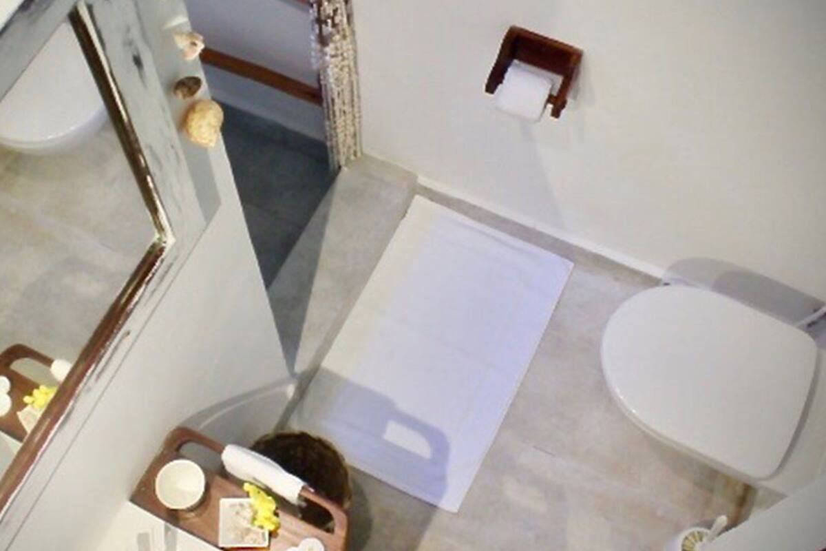 Ein Badezimmer mit Toilette, Waschbecken, Spiegel und Dusche.