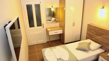 Ein Hotelzimmer mit Bett, Schreibtisch, Kleiderschrank und Spiegel.