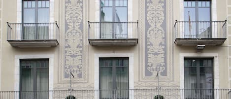 A building with multiple balconies, large windows, and decorative architectural elements.