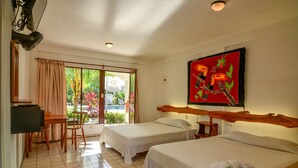 A hotel room with two beds, a desk, and a chair. There is a large window with curtains, a painting on the wall, and a television on the left. - Hotel Pochote Grande (Jacó)