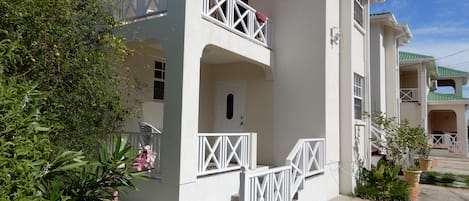 Un bâtiment à deux étages doté d’un balcon et d’une porte.