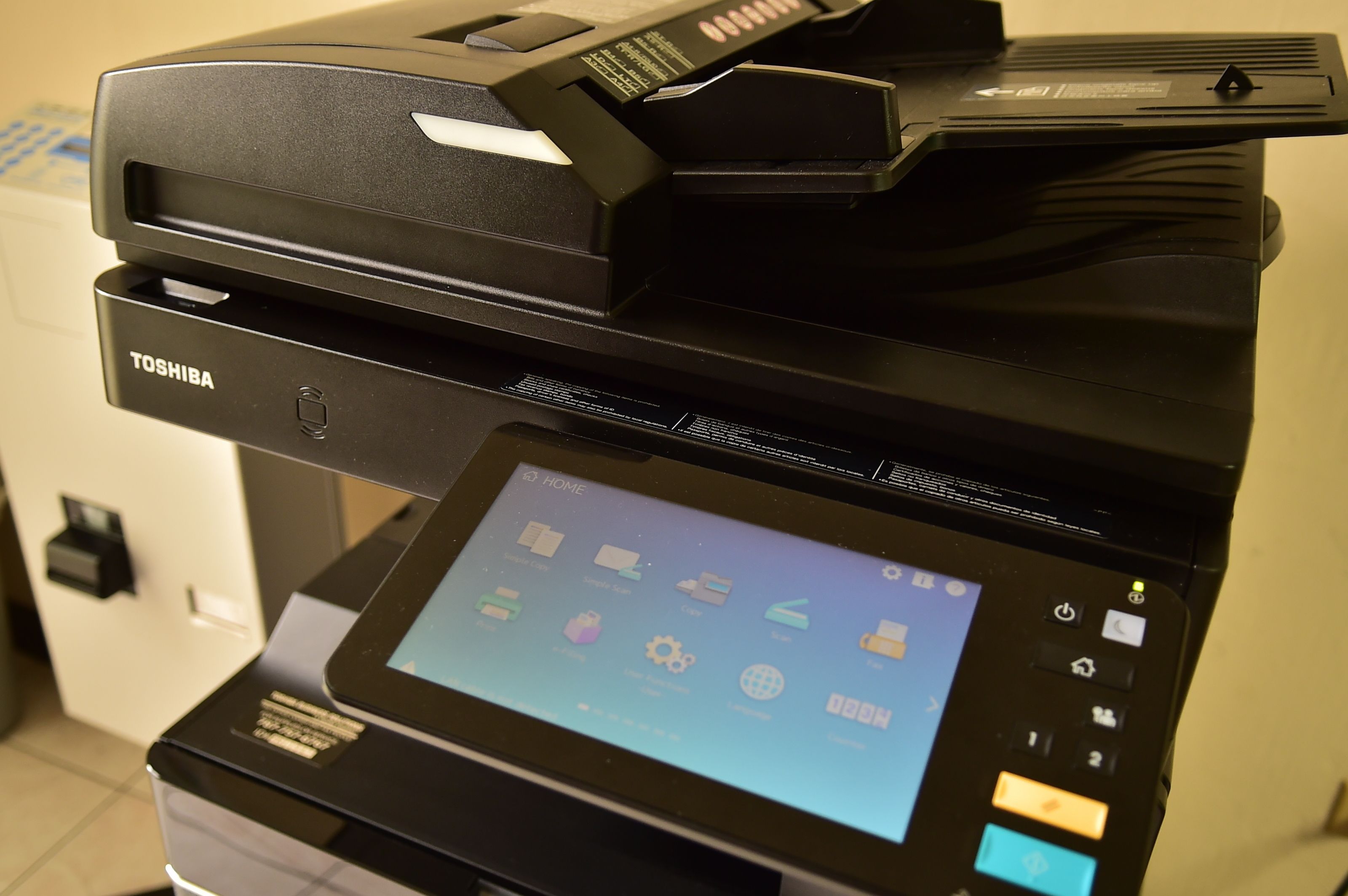 Una impressora multifuncional Toshiba amb pantalla digital i diversos icones.