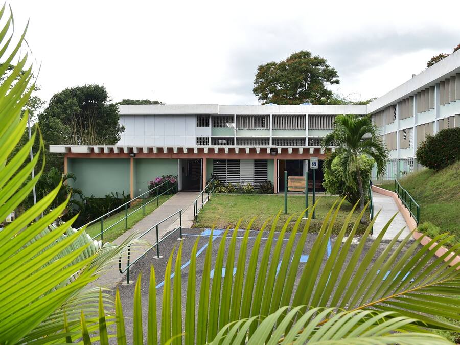 A building with a flat roof, multiple windows, and a central entrance.