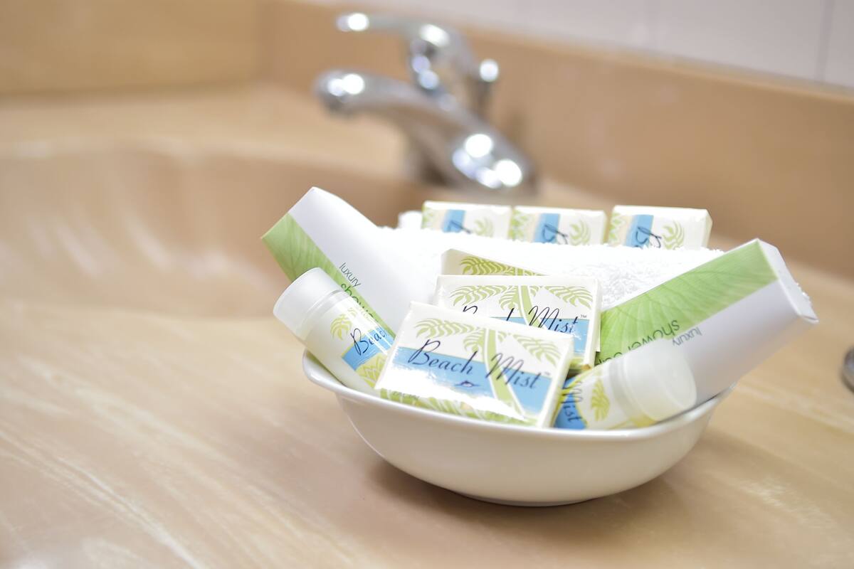 A bowl containing several bottles and packets of beach mist products.