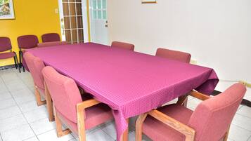Une salle de conférence avec une longue table et six chaises, une porte et des certificats encadrés accrochés au mur.
