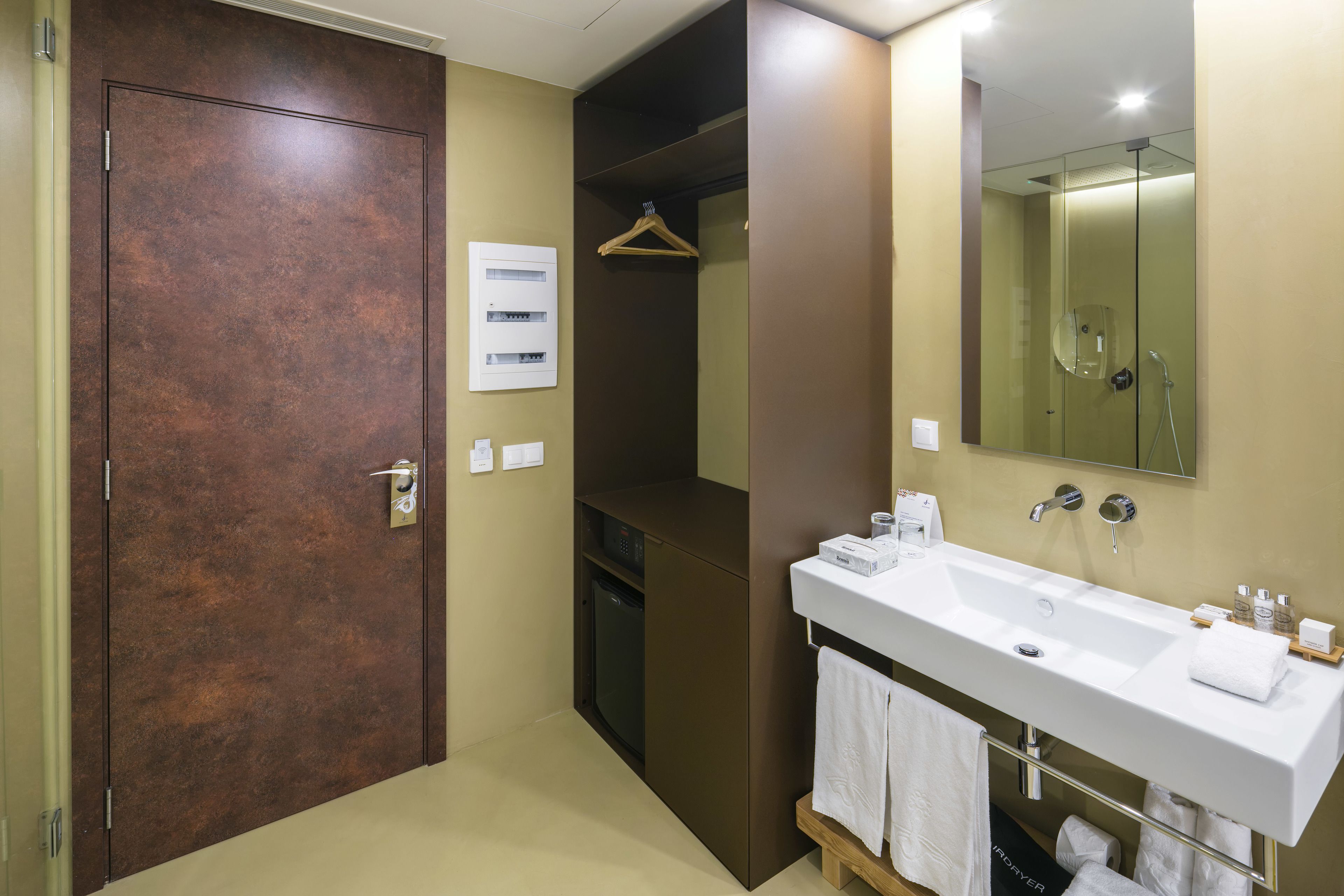 Un baño moderno con un espejo grande, un lavabo blanco y un armario de madera.
