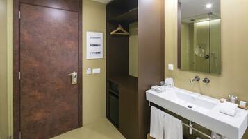 Un baño moderno con un espejo grande, un lavabo blanco y un armario de madera.