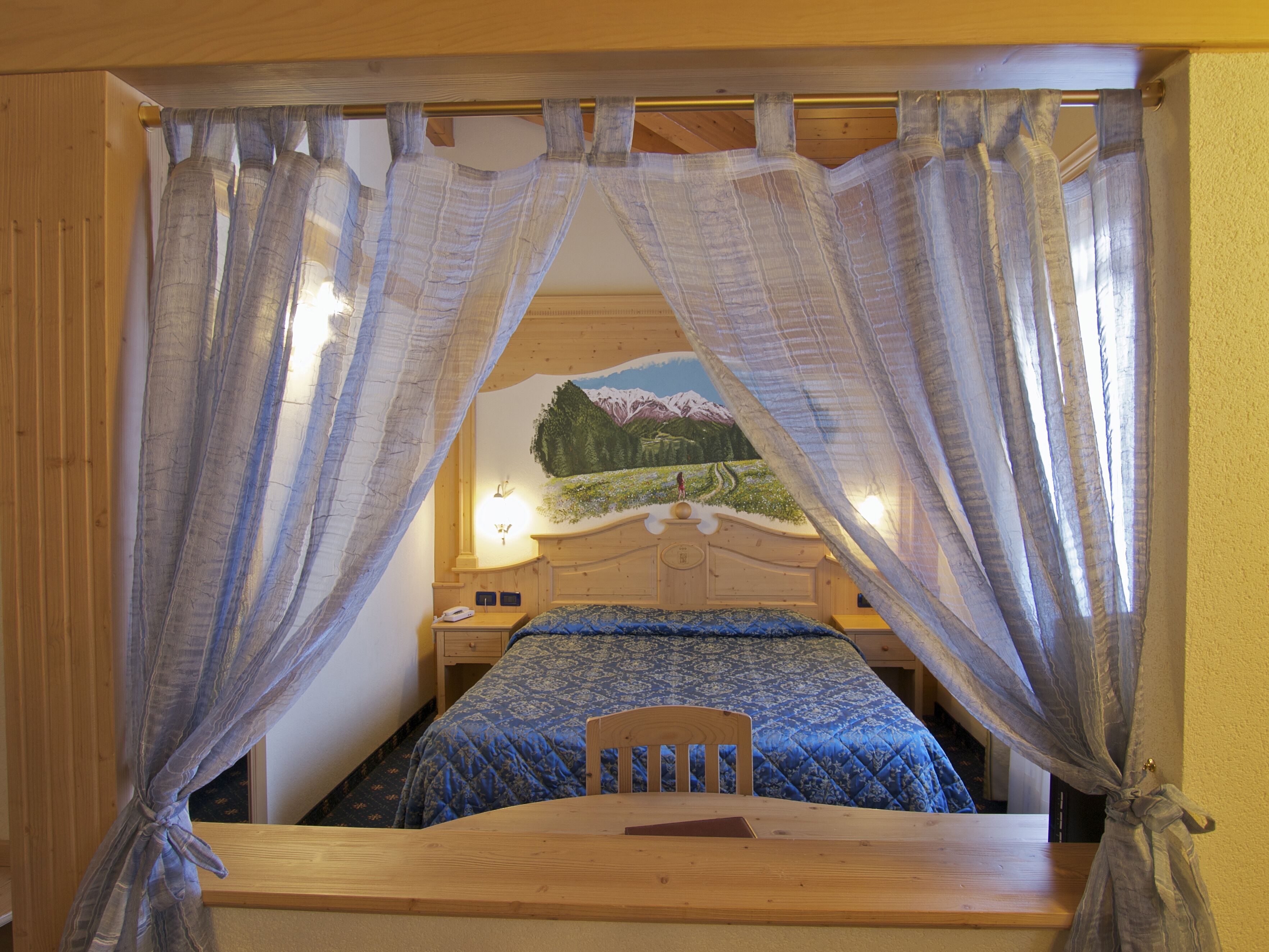 A bedroom with a bed, wooden headboard, and a nightstand.