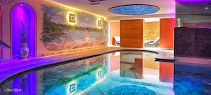 Una piscina cubierta, tumbonas