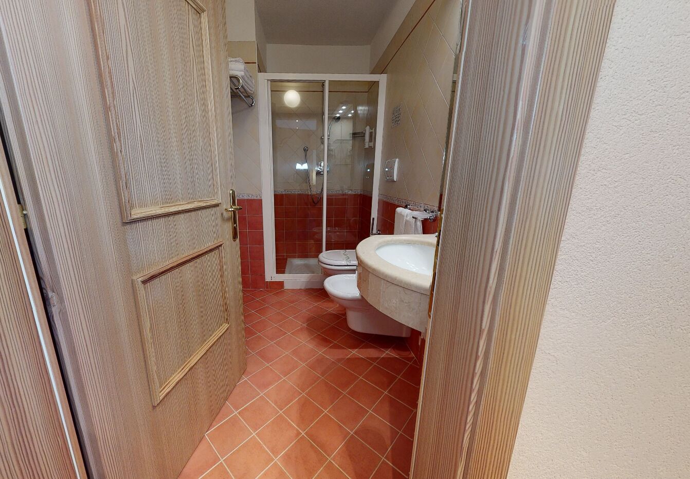 A bathroom with a shower, toilet, and sink.