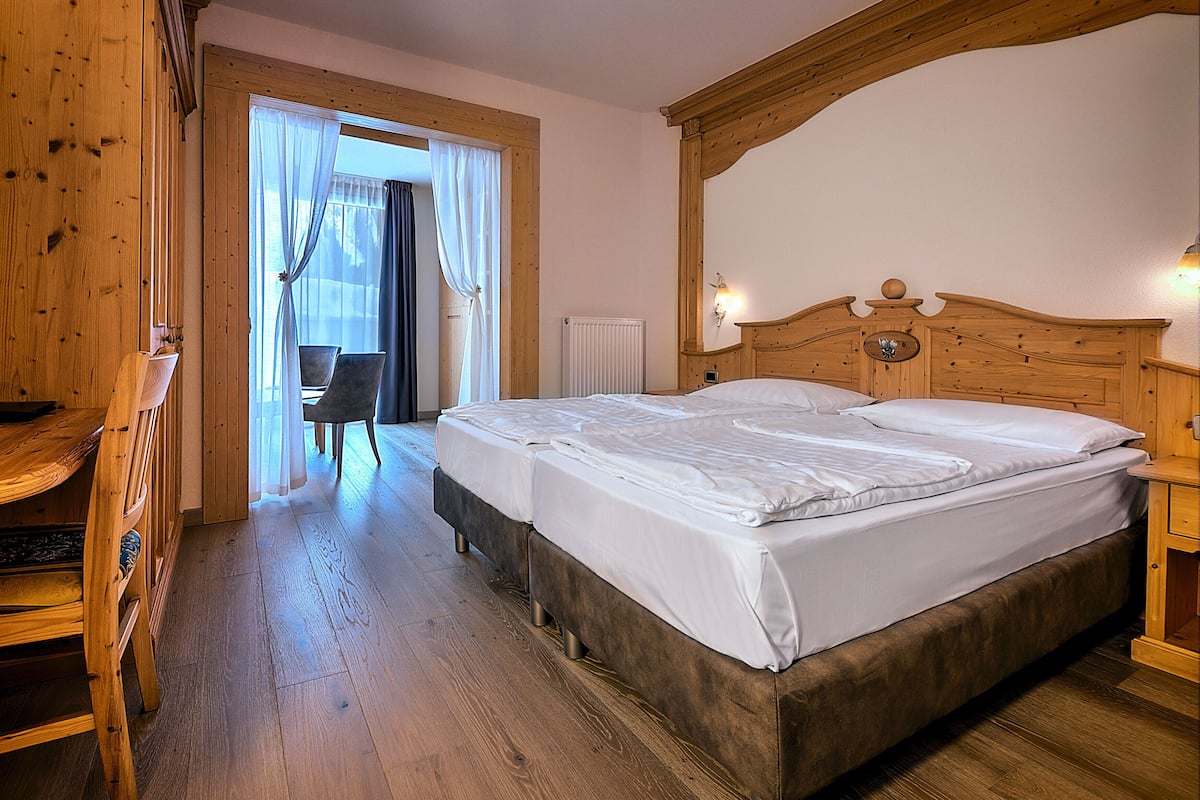 Une chambre à coucher en bois avec un lit double, une armoire en bois et une chaise.