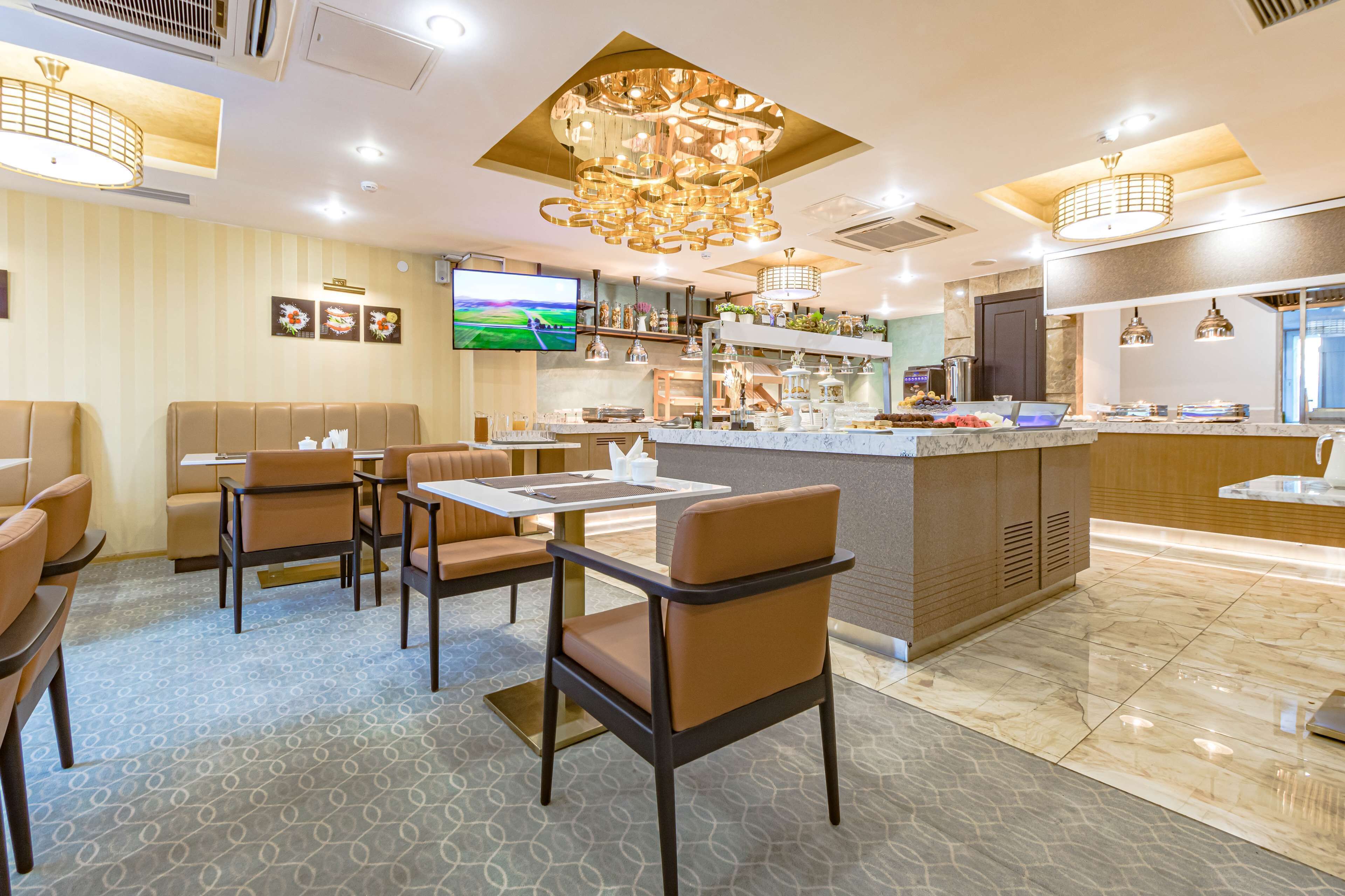 A modern restaurant with booths, tables, and a bar area.