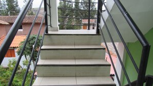A staircase with beige steps and black handrails, leading to a green wall. - Hostal Ayllu (Urubamba)