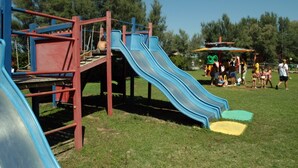Ein Spielplatz mit Rutschen und Klettergerüsten.