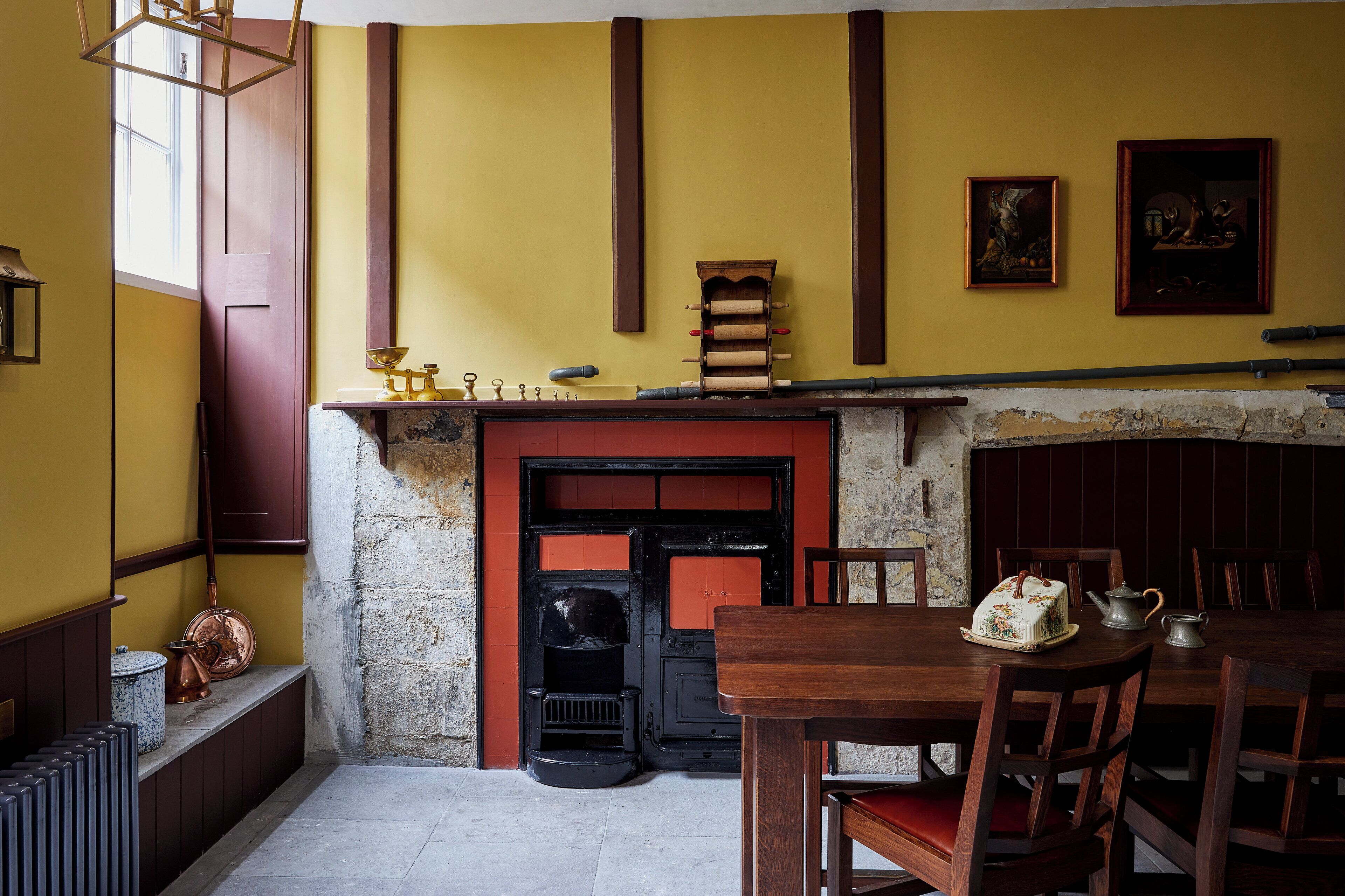 A room with a fireplace, wooden furniture, and a table with a teapot and a decorative item.