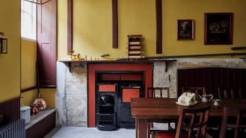 A room with a fireplace, wooden furniture, and a table with a teapot and a decorative item.