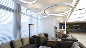 A modern lounge area with sofas, a coffee table, and a reception desk. - Ramada Encore by Wyndham Haeundae (Busan)