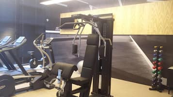 A gym with exercise equipment including treadmills, a weight bench, and a pull-up bar.