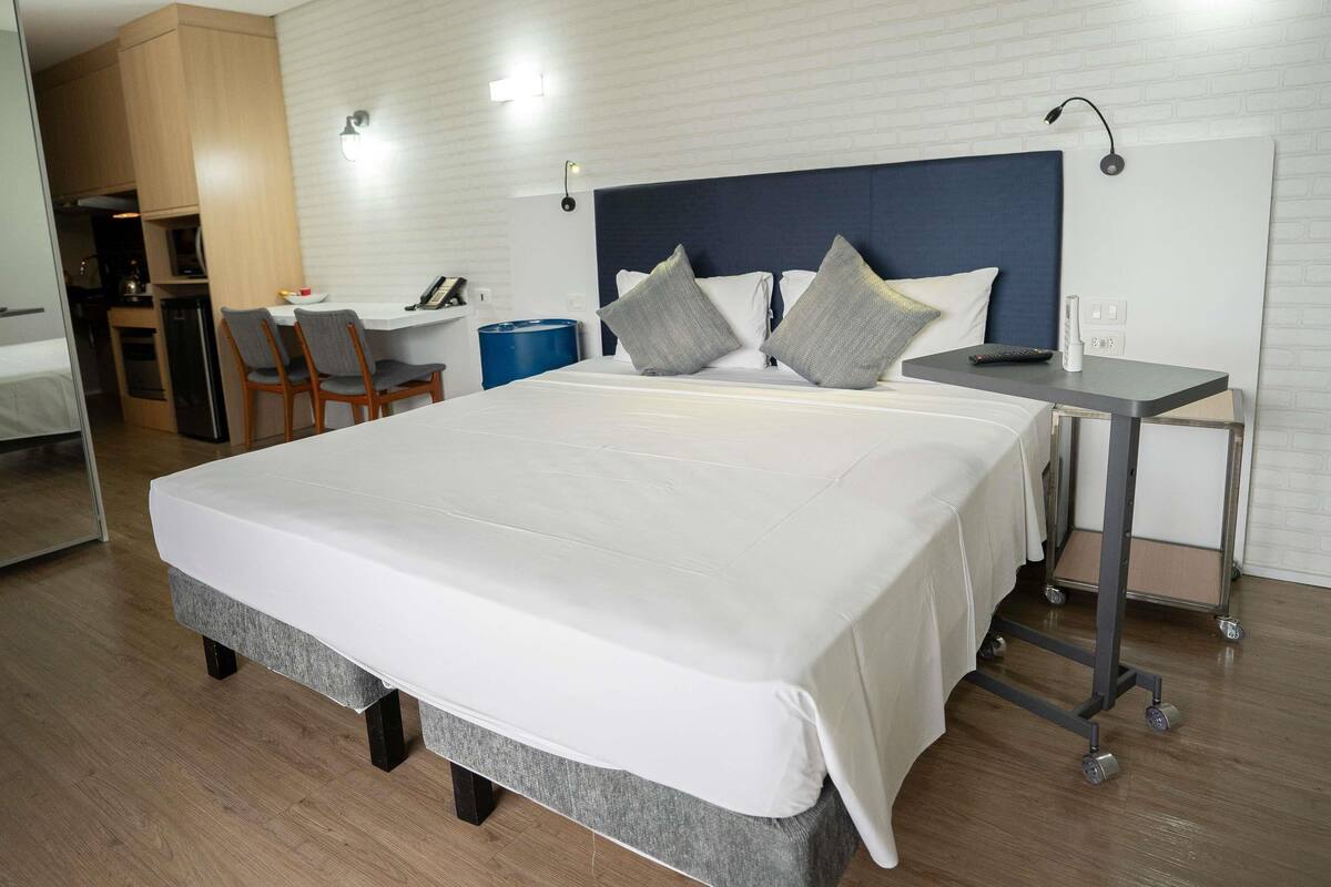 Une chambre d’hôtel moderne, dotée d’un grand lit, d’un bureau et d’une chaise.
